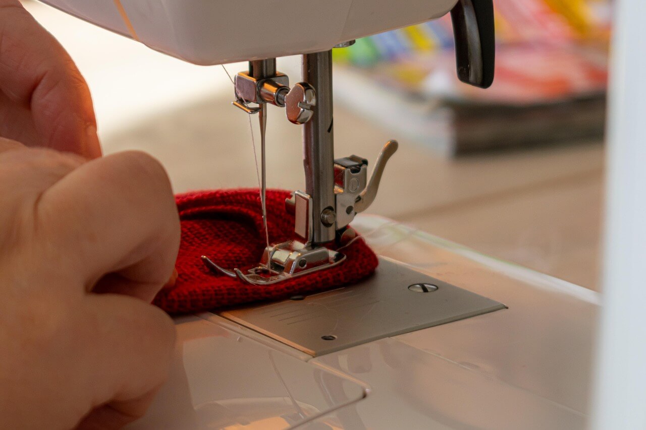 hand at a sewing machine depicting a teen making things for extra cash